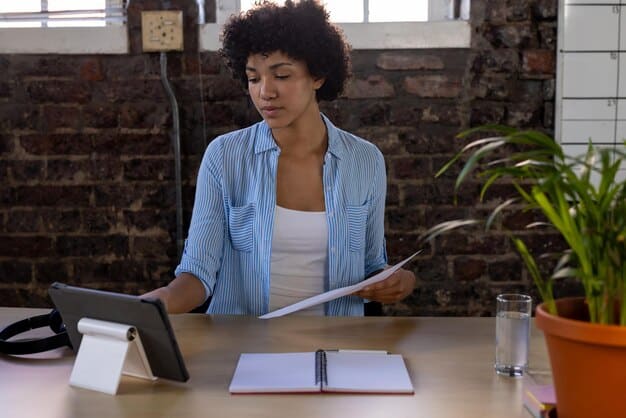 A photo of a Colombian citizen filling out an application form, emphasizing the importance of proper documentation for unemployment benefits. The setting is a modern office environment.