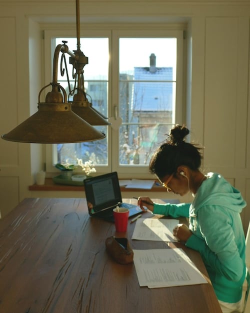 A photo of a Colombian citizen sitting at a desk, carefully organizing documents and writing a letter of appeal for a denied government subsidy. The focus is on their determined expression and the importance of meticulous preparation.
