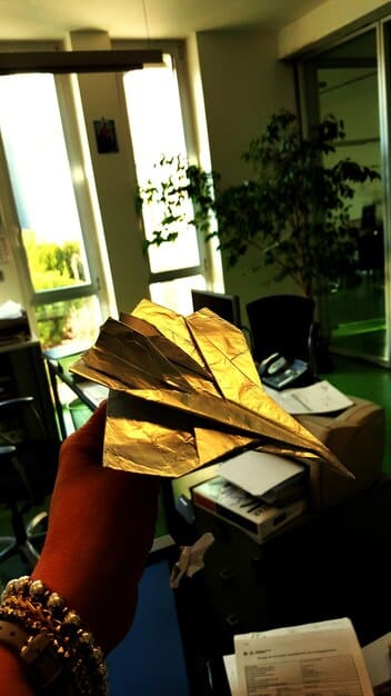 A close-up of a Colombian document showing a credit agreement with emphasis on the section calculating the CAT, highlighted with a magnifying glass.  The setting is a modern office desk.