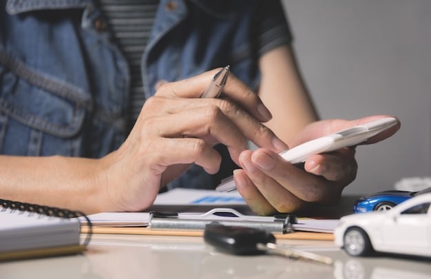 A close-up of a person using a car loan calculator app on their smartphone, with a sleek car key and a calculator placed nearby.