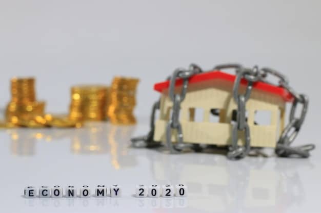 A close-up image of a Colombian peso bill with a miniature house on top, symbolizing savings for a home. The background is blurred and shows various coins and financial documents.