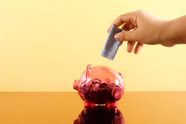 A close-up of a person's hands carefully placing coins into a clear piggy bank against a blurred background of financial documents and a calculator. The warm lighting highlights the coins and the act of saving.