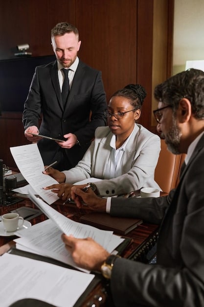A diverse group of lawyers and paralegals studying legal documents in a modern law office. The team is using digital tools to analyze property records, highlighting collaboration and technology to find legal protection.